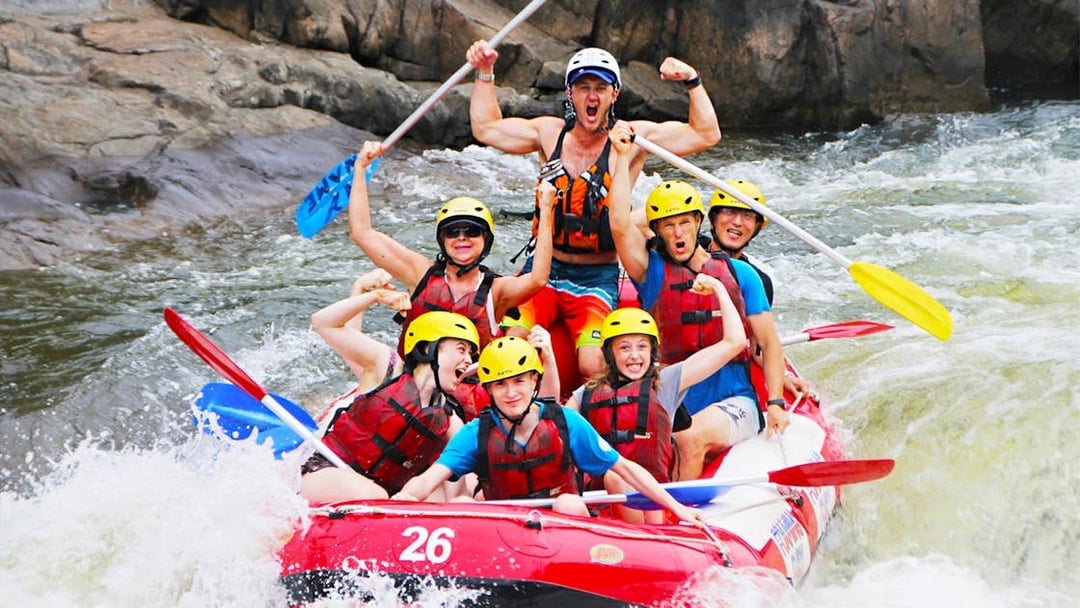 Group rafting on Barron River, Australia, navigating rapids with excitement.