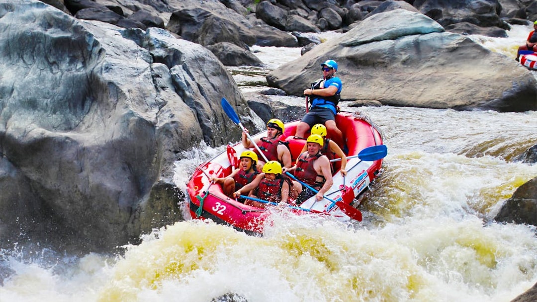 Raft navigating rapids on Barron River during half-day tour.