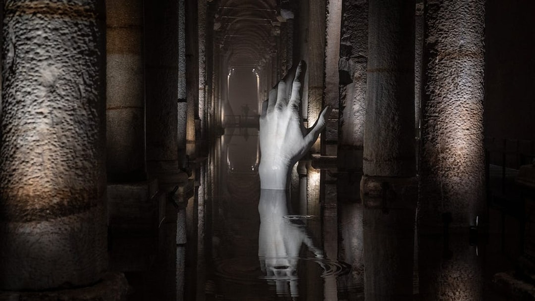 Basilica Cistern interior with illuminated columns and submerged hand sculpture, Istanbul.