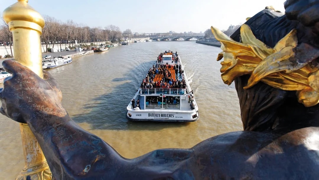 Bateaux Mouches boat cruising on the Seine River in Paris with passengers enjoying live music.