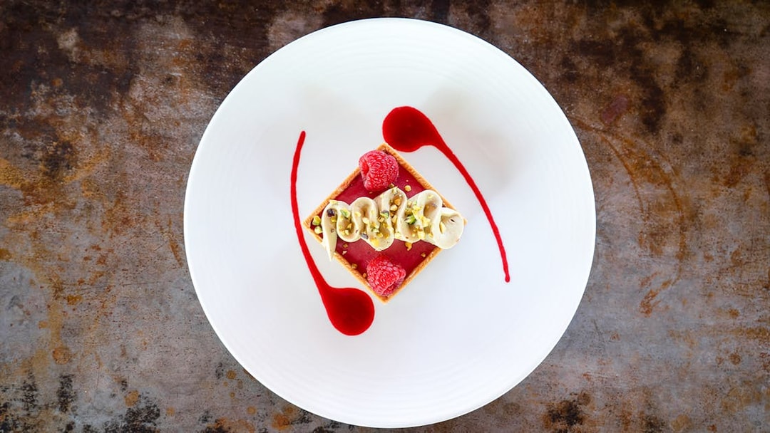 Dessert with raspberries and cream on a white plate at Bateaux Mouches, Paris.