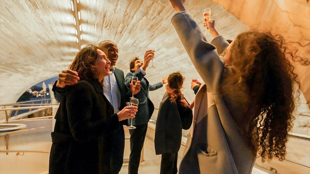 Guests toasting on a Bateaux Mouches Seine River dinner cruise in Paris.