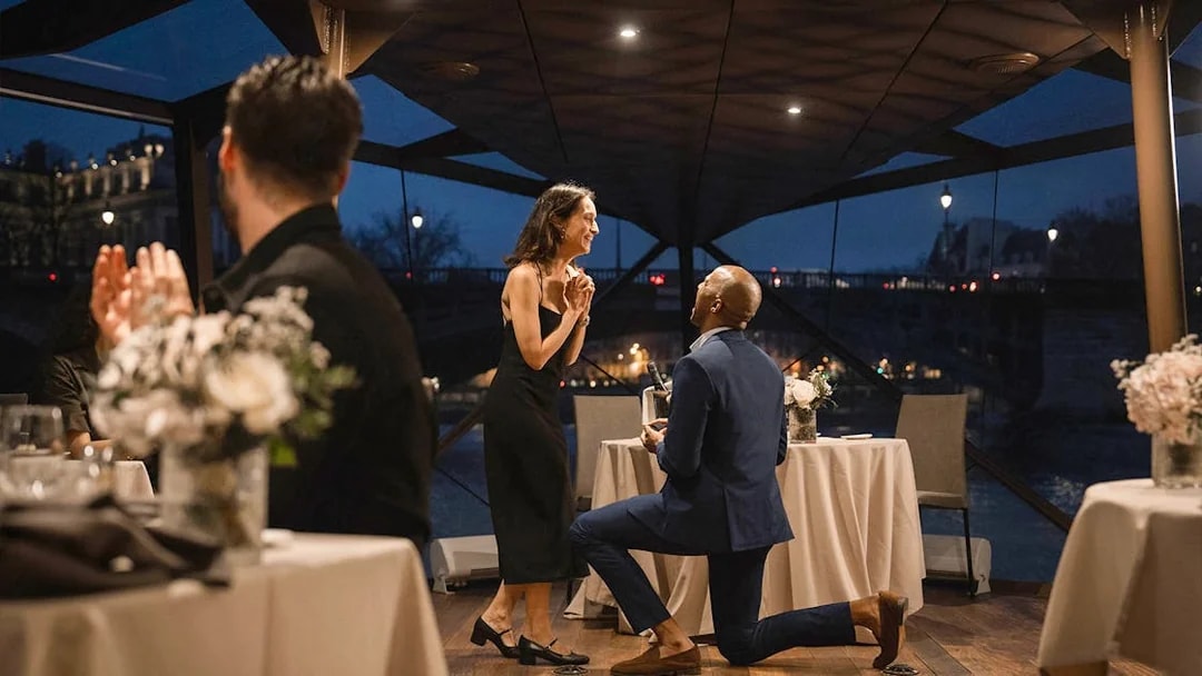 Couple engaged on Bateaux Mouches Seine River dinner cruise in Paris.