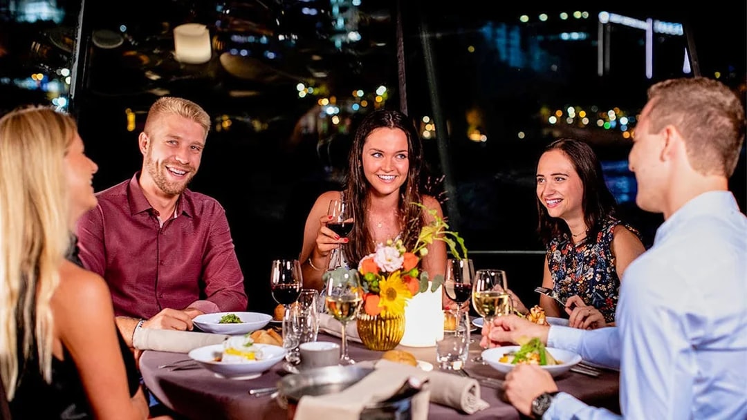 Guests enjoying dinner on a Seine River sightseeing cruise.