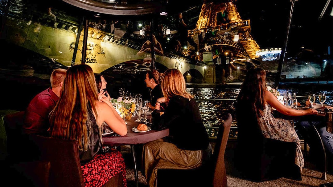 Dining on Seine River cruise with Eiffel Tower view at night.