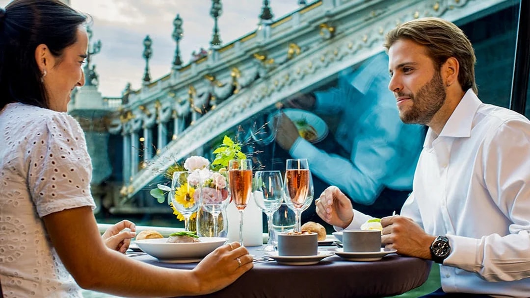 Dinner on a Seine River cruise with view of ornate bridge in Paris.