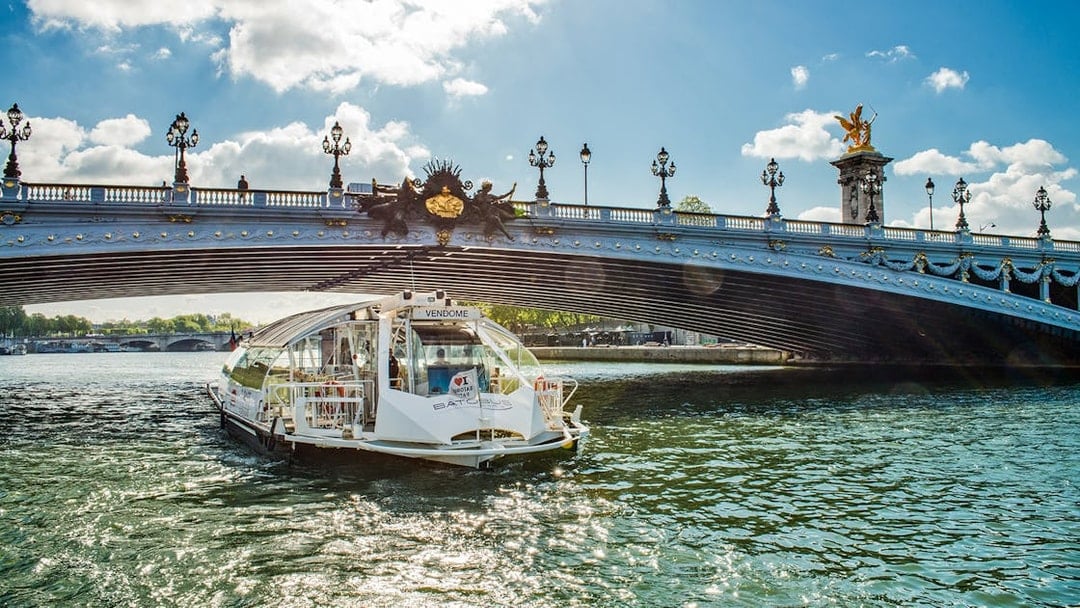 Batobus cruising under Pont Alexandre III in Paris on a sunny day.