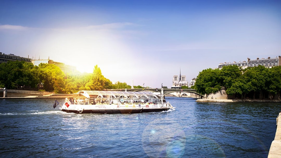 Batobus cruising on the Seine River with Notre-Dame Cathedral in the background, Paris.