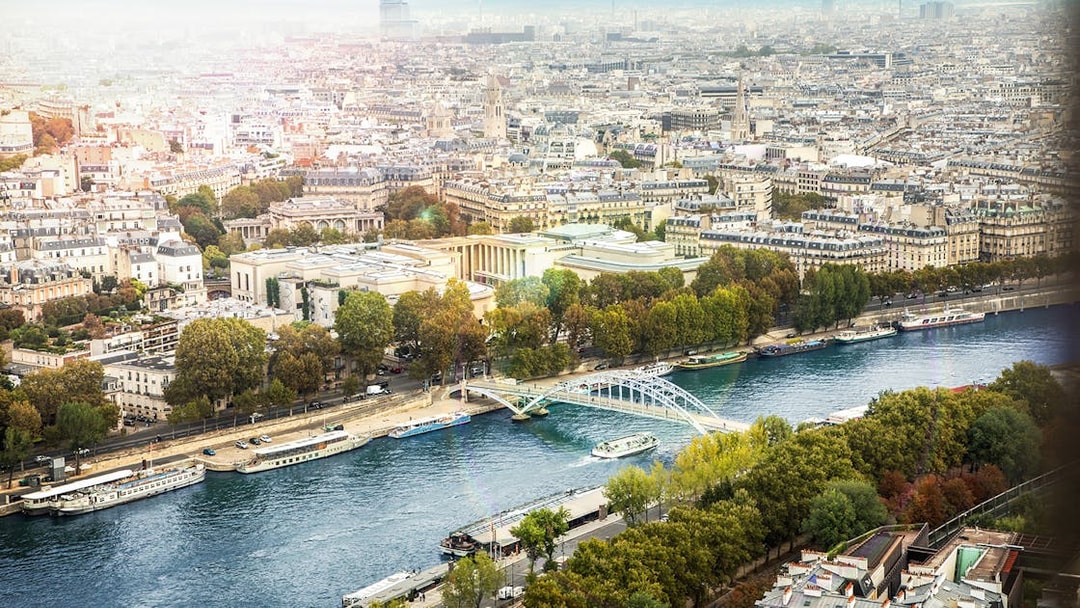 Aerial view of Seine River with Batobus boats and Paris cityscape.