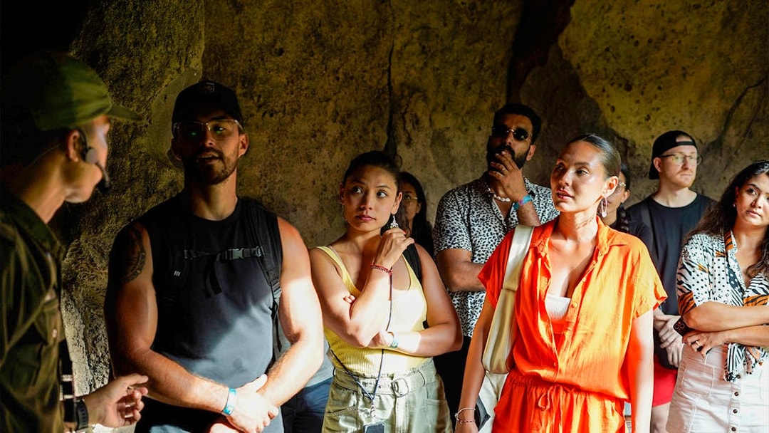 Tour group attentively listens to guide inside Bali Zoo.