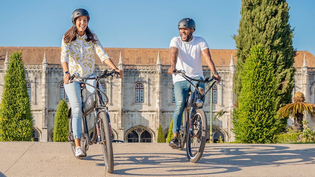 Cyclists enjoying Lisbon e-bike tour near historic Belém landmark.