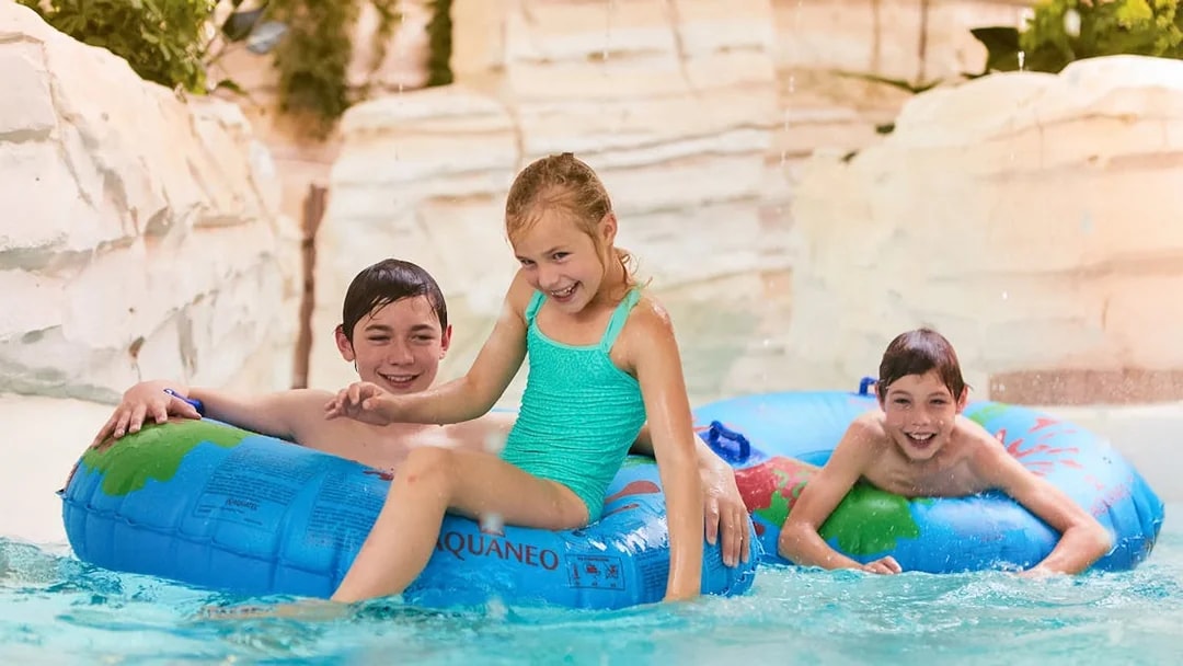Children playing in jungle-themed water area at Bellewaerde Aquapark, Belgium.
