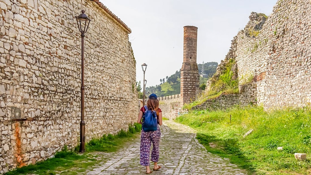 Guest walking along stone path inside Berat Castle, Albania.