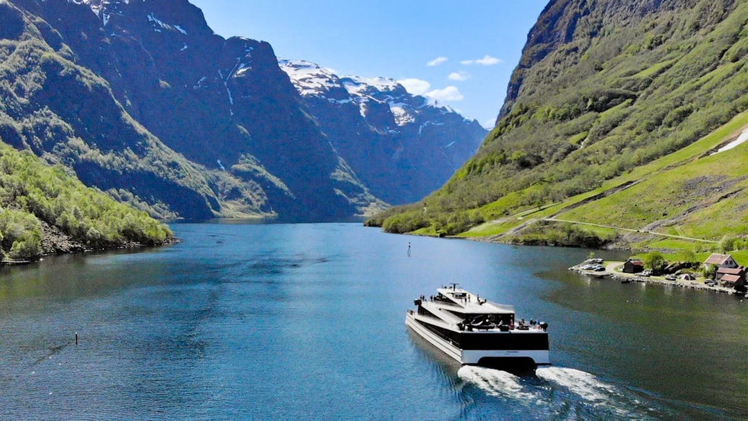 Cruise ship on Nærøyfjord surrounded by steep mountains, Norway.