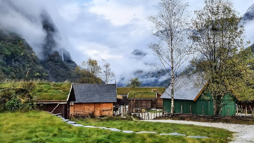 Viking village with grass-roofed houses in a misty valley near Bergen, Norway.
