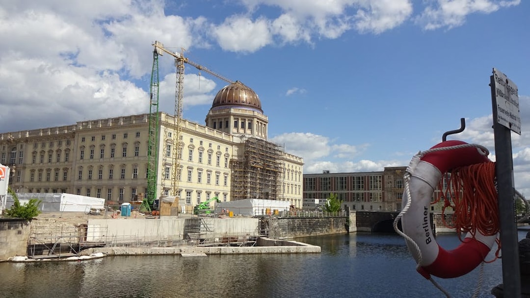 Berlin Palace under construction by the River Spree with a life preserver in the foreground.