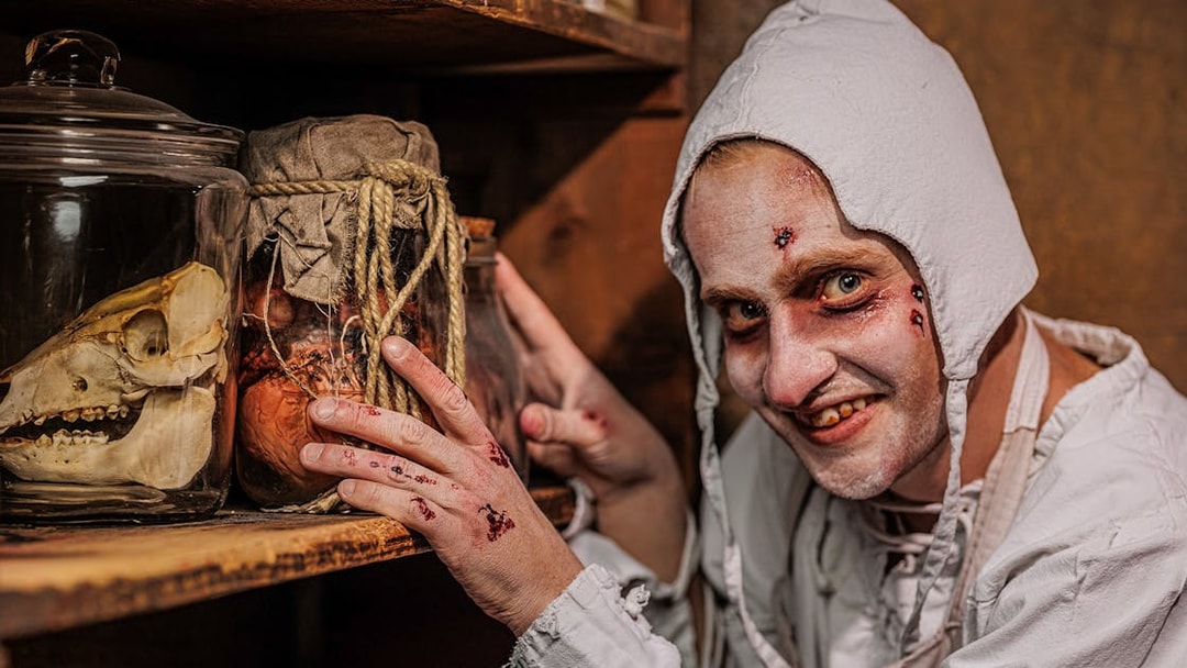 Plague doctor character with jars at Berlin Dungeon exhibit.