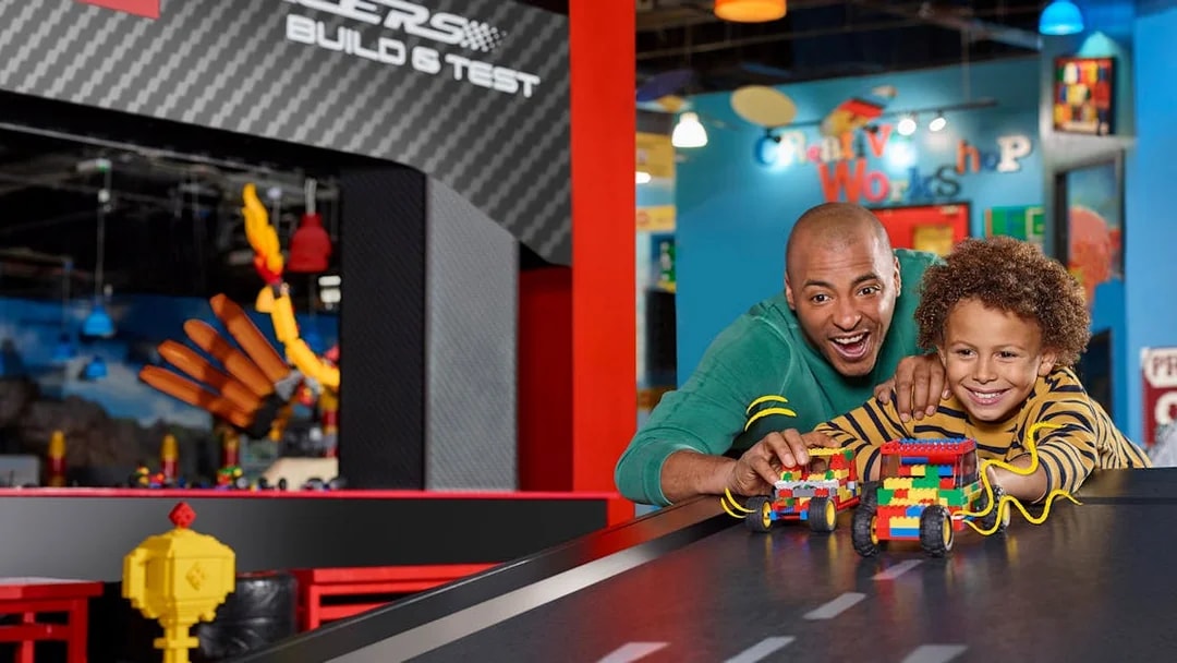 Families enjoying interactive Lego car racing at LEGOLAND Discovery Centre Berlin.