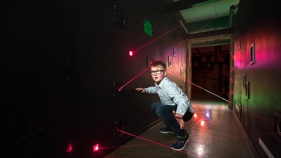 Child navigating laser maze at LEGO Ninjago, LEGOLAND Discovery Centre Berlin.