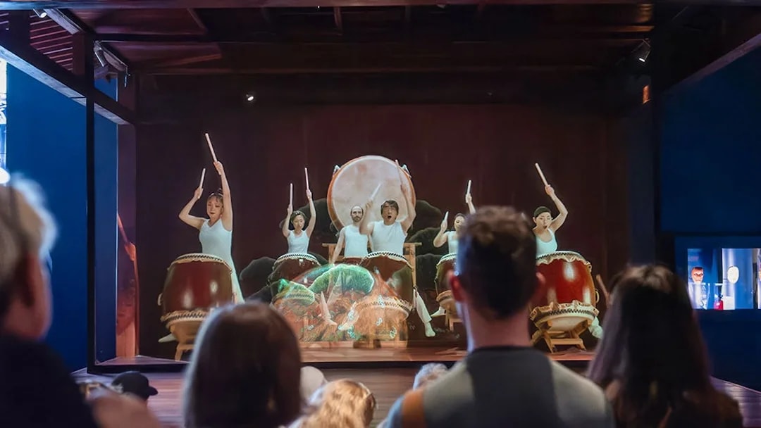 Taiko drummers performing at Samurai Museum, engaging audience in cultural experience.