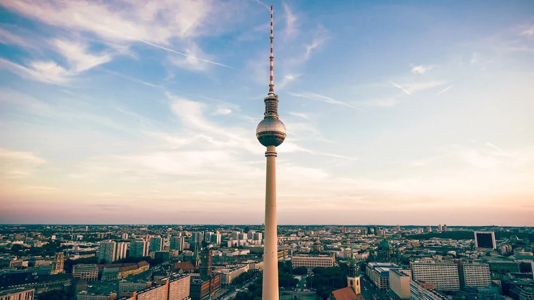 Berlin TV Tower overlooking cityscape at sunset.