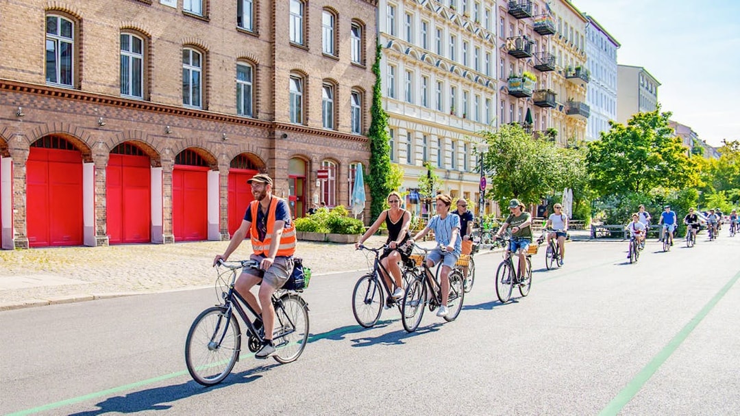 Cyclists on a guided tour ride past historic buildings in Berlin.