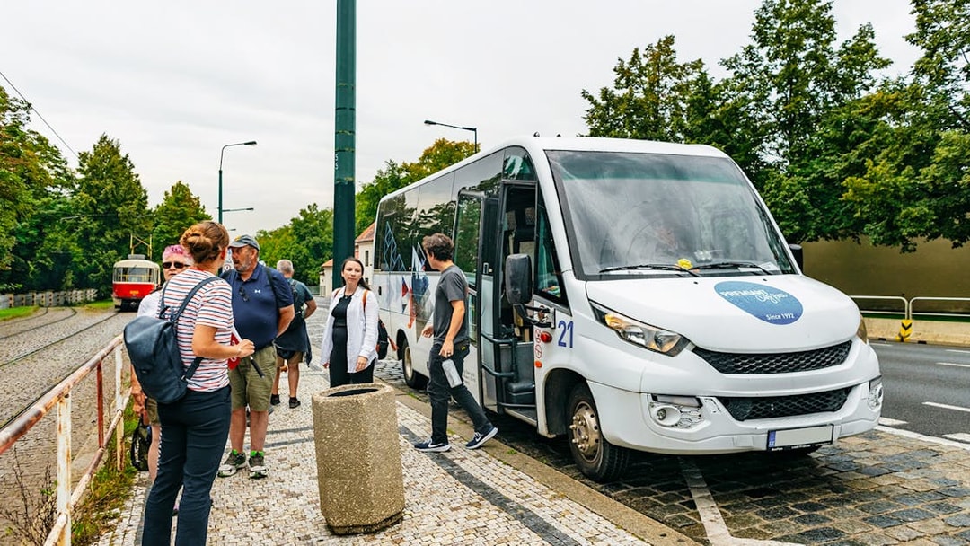 Tourists boarding a bus in Prague for a city tour by boat, bus, and on foot.