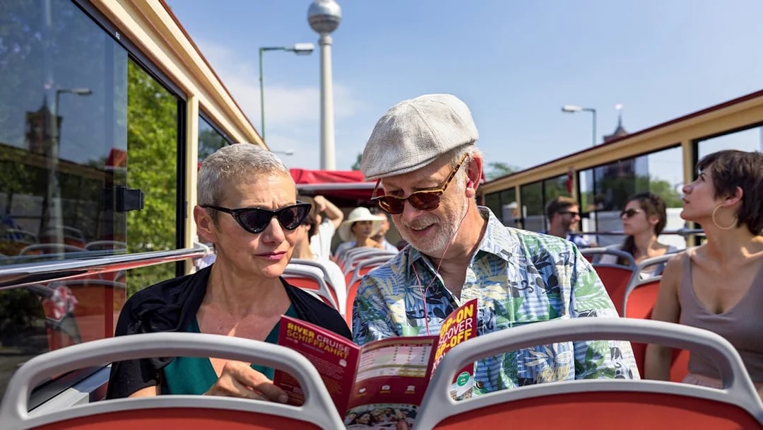 Couple on Berlin BigBus tour reading route map with TV Tower in background.