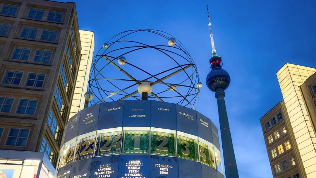 World clock and TV tower in Berlin during panoramic day and evening tour.