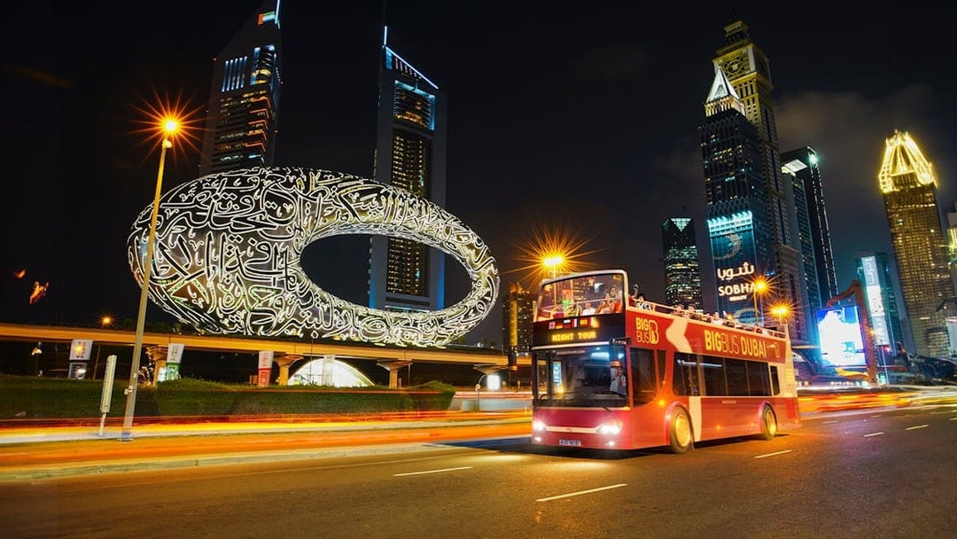 Big Bus Dubai Night Tour passing the Museum of the Future and skyscrapers.
