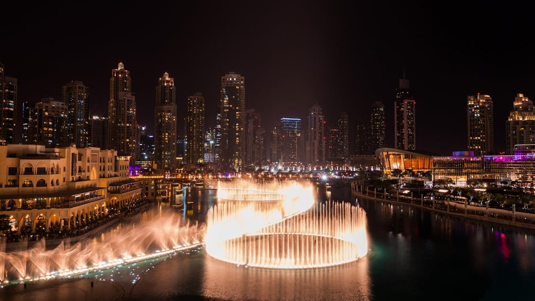 Dubai Fountain show at night with city skyline, viewed from Big Bus Dubai Night Tour.