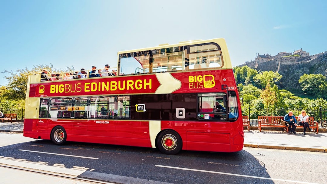Edinburgh hop-on hop-off bus with Edinburgh Castle in the background.