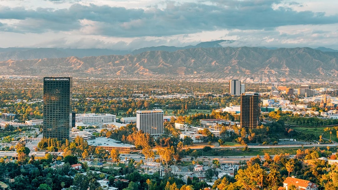 Skyline view of Los Angeles with mountains, highlighting celebrity homes tour area.