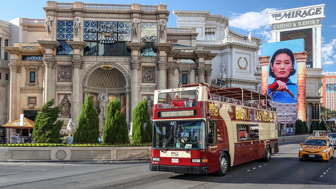Big Bus tour passing Caesars Palace on Las Vegas Strip.