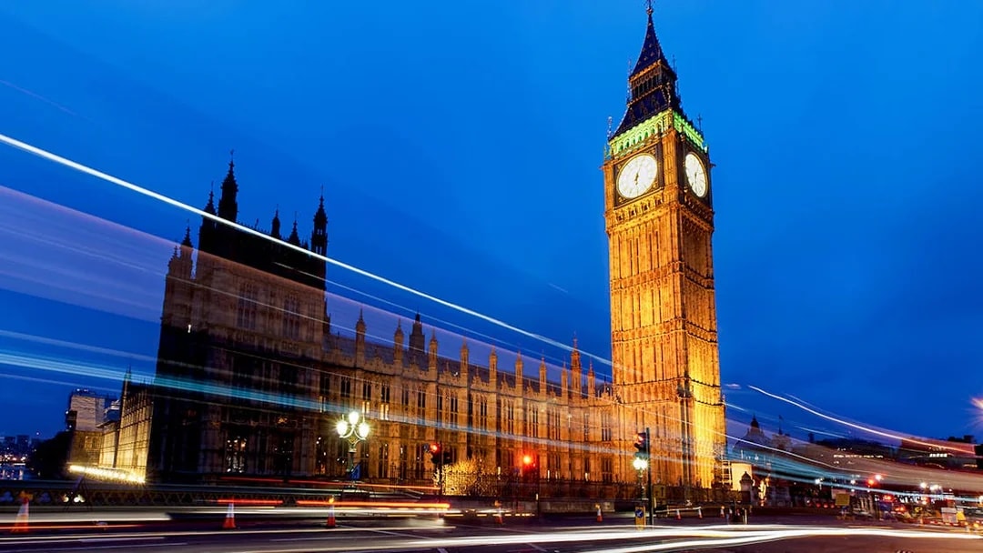 Big Ben and Houses of Parliament illuminated at night, London, viewed from a moving bus.