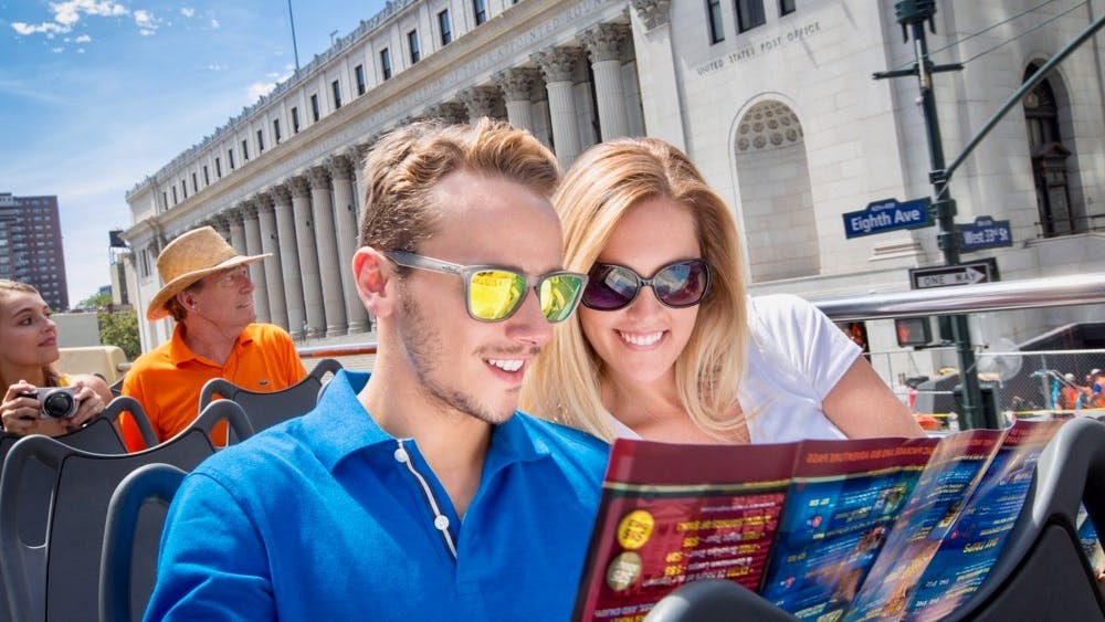 Open-top bus tour in New York City with passengers viewing a map near the U.S. Post Office on Eighth Ave.