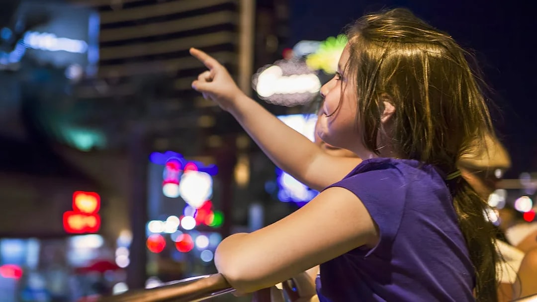 Tourist pointing at city lights on San Francisco hop-on hop-off bus tour.