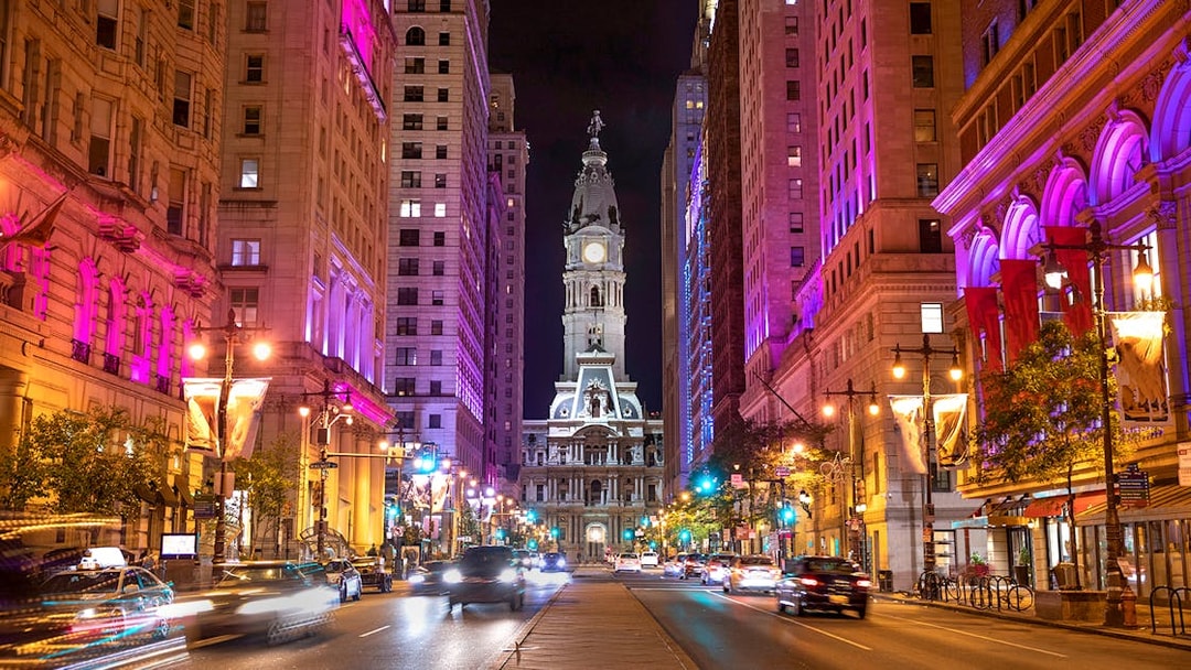 Philadelphia City Hall illuminated at night with vibrant street lights.