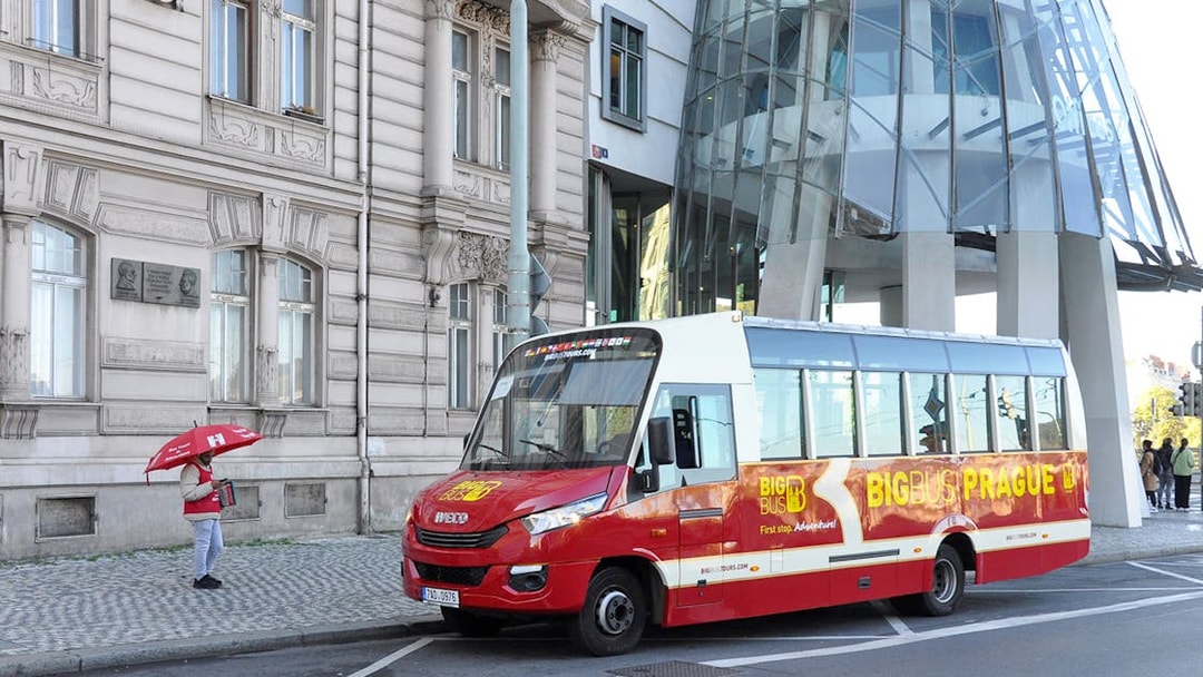 Hop-on hop-off tour bus in front of Prague's Dancing House.