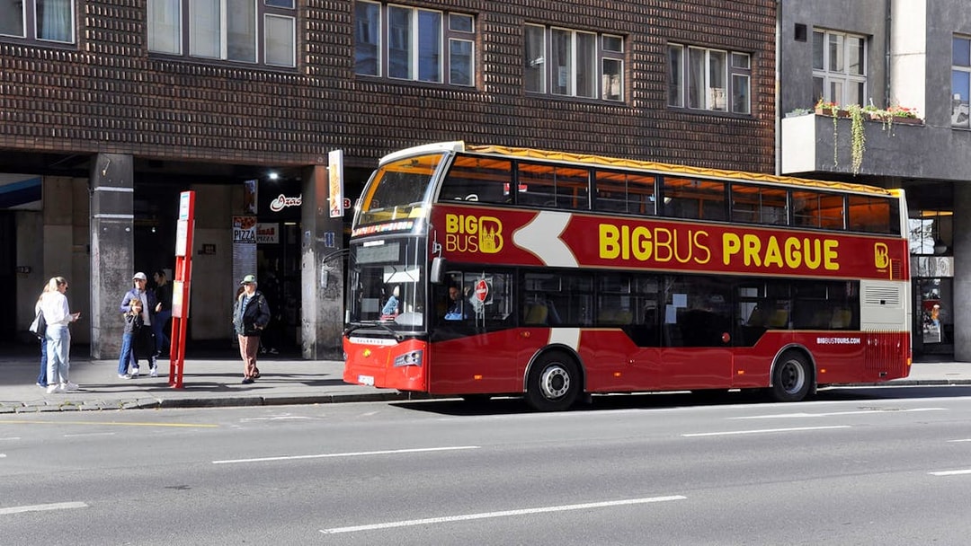 People waiting at a bus stop for the Big Bus Hop on Hop Off tour in Prague.