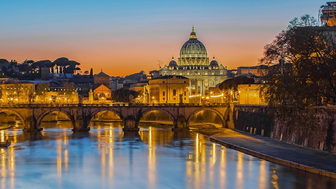 St. Peter's Basilica and Tiber River at sunset, Rome night bus tour.