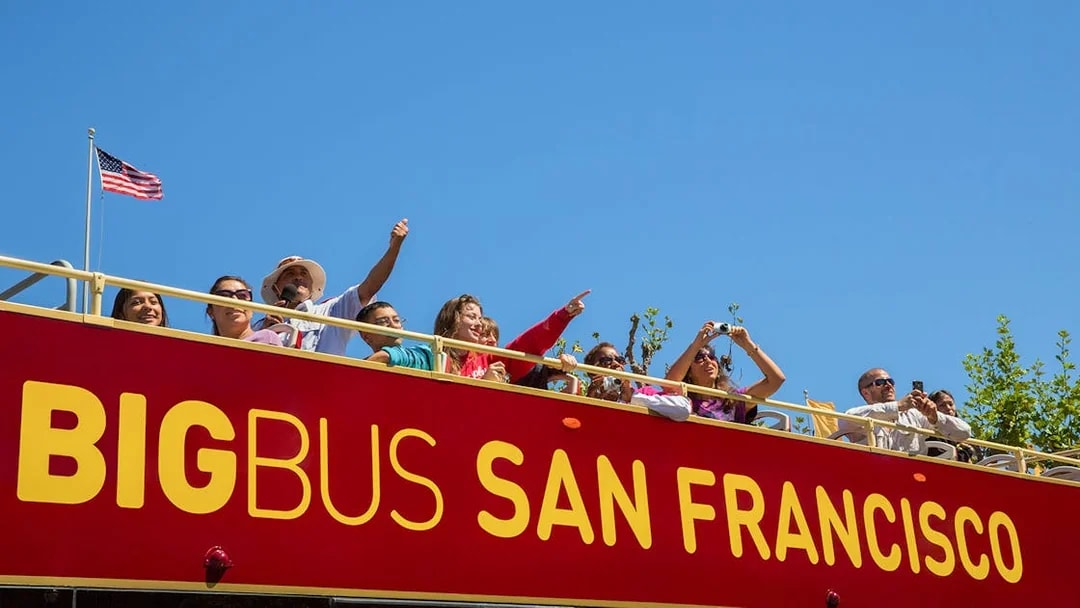 Tourists on a San Francisco hop-on hop-off bus enjoying city views.