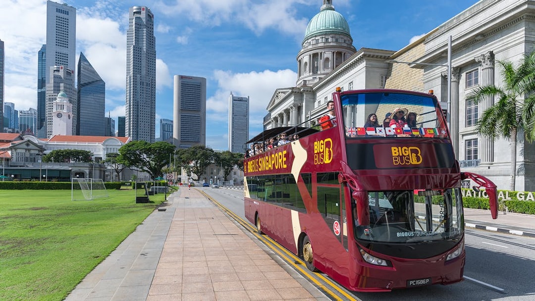 Singapore Hop-On-Hop-Off bus near National Gallery with city skyline.