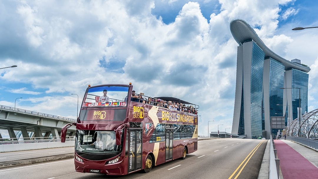 Big Bus tour near Marina Bay Sands, Singapore with passengers on top deck.