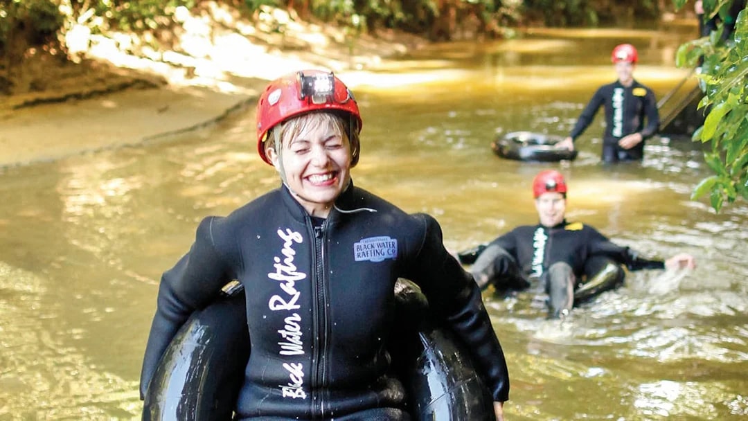 Participants enjoying black water rafting in Waitomo cave stream.