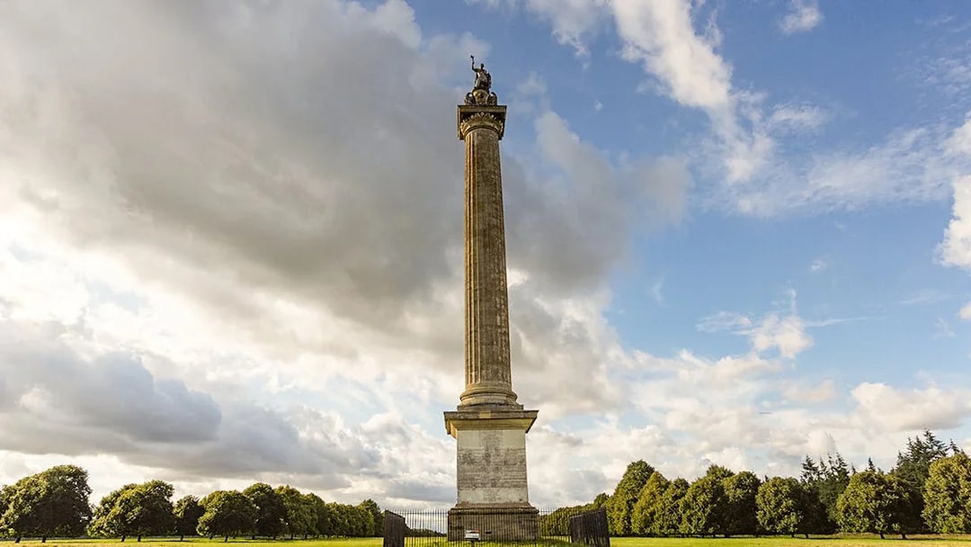Column of Victory in Parkland at Blenheim, surrounded by trees and open sky.