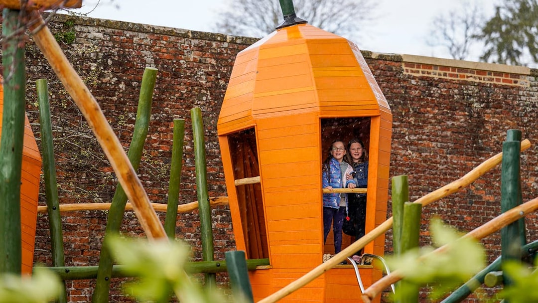 Children playing in a wooden structure at Blenheim Palace Adventure Play.