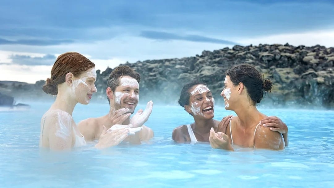 Tourists applying silica mud at Blue Lagoon Geothermal Pool, Iceland.