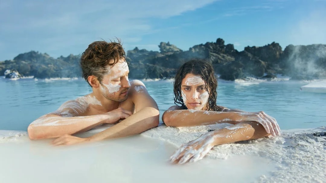 Couple relaxing in geothermal waters at Blue Lagoon, Iceland.