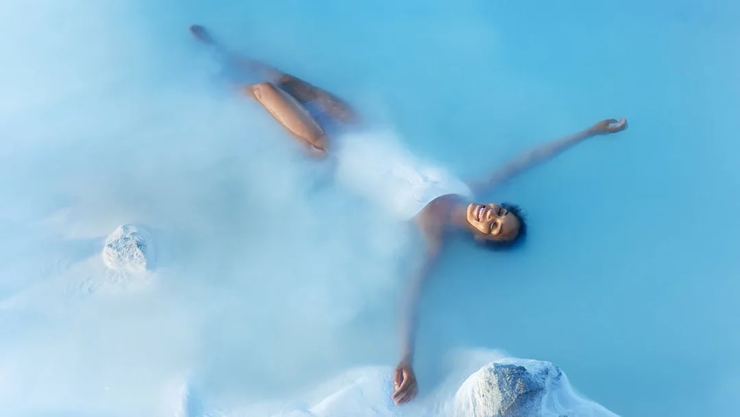 Tourist enjoying a bath in Blue Lagoon Geothermal Pool, Iceland.
